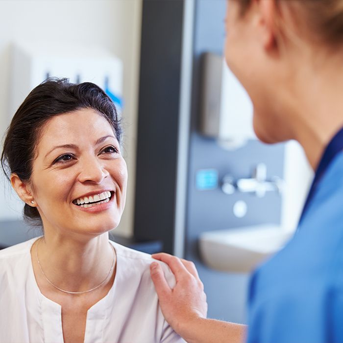 Woman in dental office smiling at dentist
