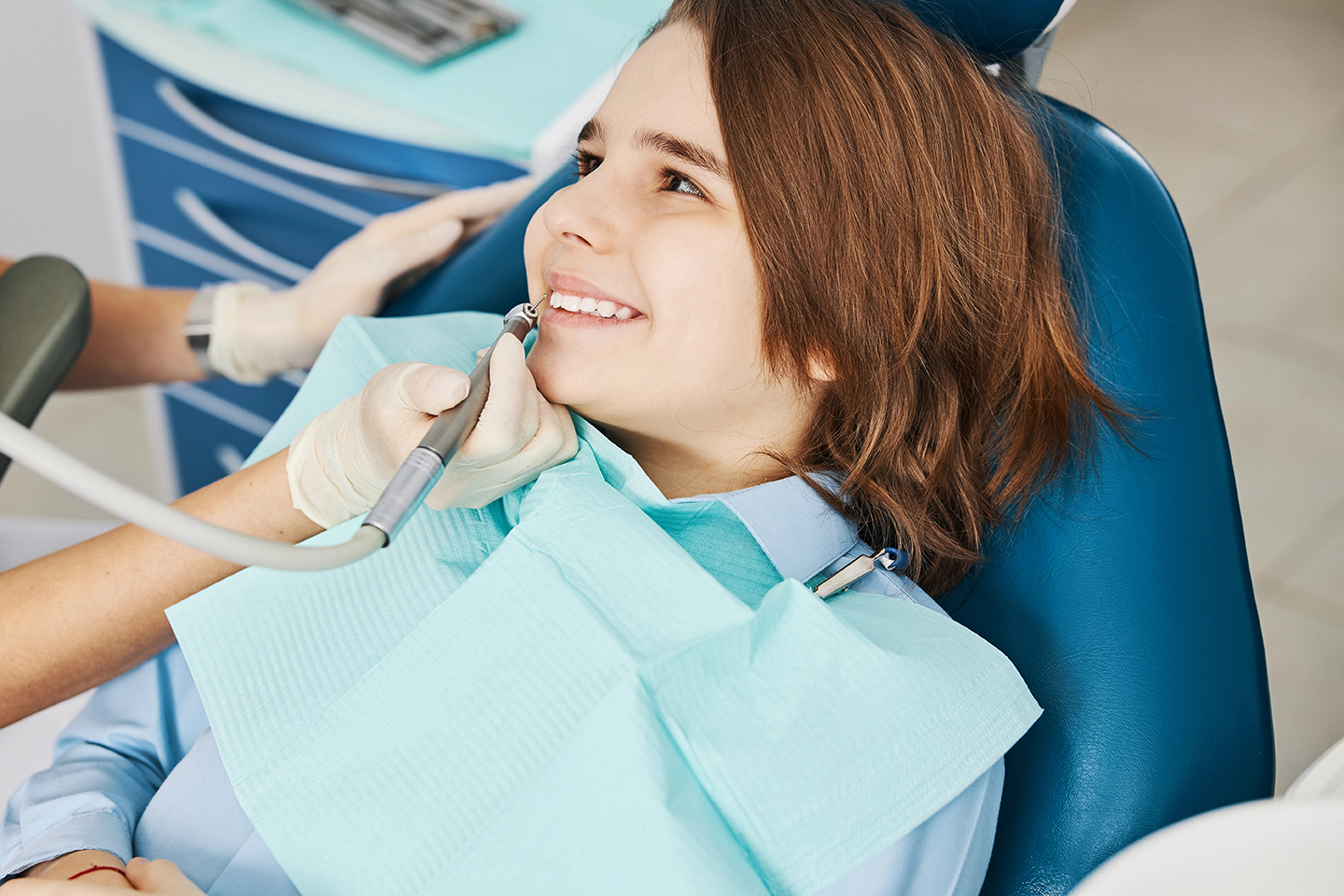 Kid turning his head and looking at his operating dental surgeon with smile on his face