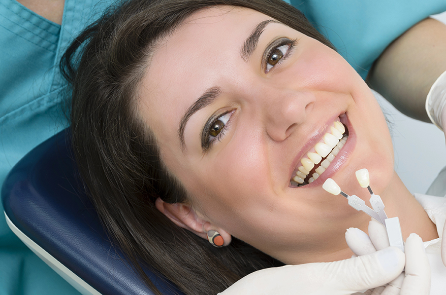 A dentist showing porcelain teeth to pacient